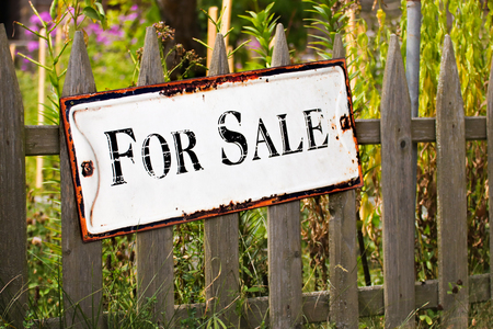 Sign for sale on a wooden fence on the garden.の写真素材