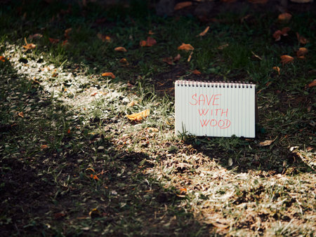 Spiral notebook standing like a calendar on grass with warm sunlight streaming from top left corner across pages, creative eco-friendly concept, natural outdoor sceneの写真素材