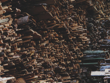 Stacked firewood filling the frame, multiple layers of cut logs creating a rich pattern of textures and tones, warm matte finish enhancing the natural character of the wood, authentic rustic composition ideal for environmental or seasonal visuals.の写真素材