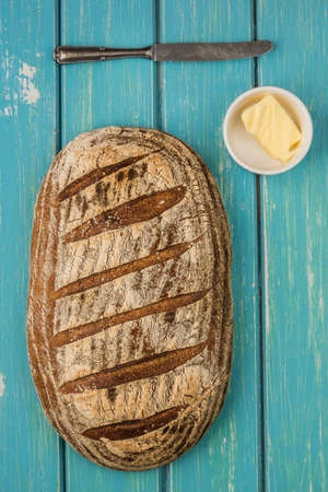 One loaf of sourdough bread on blue bable board