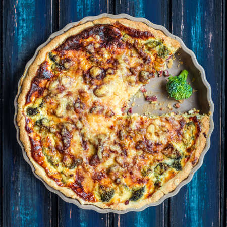 Broccoli quiche made in the oven and presented on a blue wooden boardの写真素材