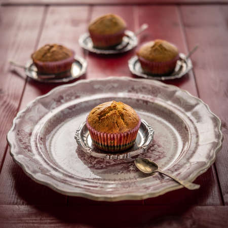 Poppy seeds muffins on a red decorated vintage plateの写真素材