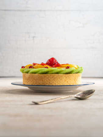 Fruit tart with kiwi, peaches, strawberries, raspberries and grenade seeds