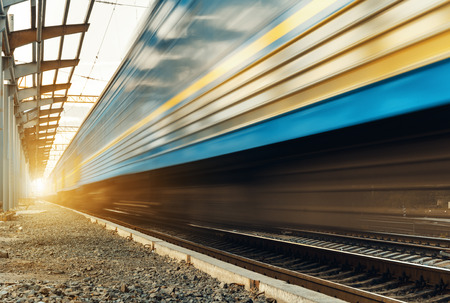 High speed passenger train on tracks with motion blur effect at sunset. Railway station in Ukraineの写真素材