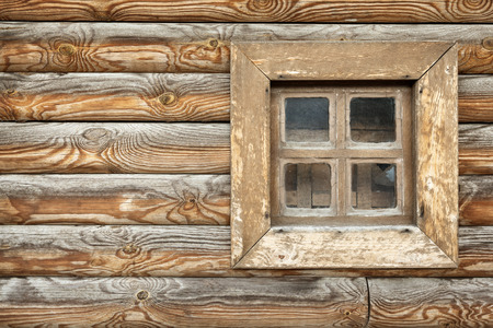 Old window of the old wooden house on the background of wooden wallsの写真素材