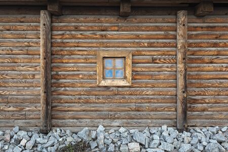 Old window of the old wooden house on the background of wooden wallsの写真素材