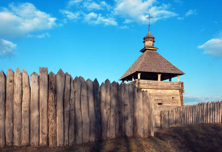 Old wood rustic church building and wooden fence against blue sky at sunsetの写真素材