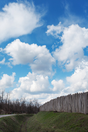 Old wooden fence against blue sky with clouds. Background for designの写真素材