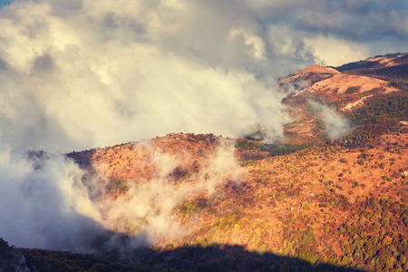 Dramatic mountain autumn landscape at sunset. Low clouds. Nature backgroundの写真素材