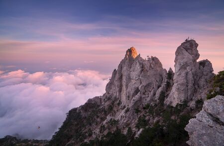 Top of the mountains. High rocks with low clouds at sunset. Colorful nature backgroundの写真素材