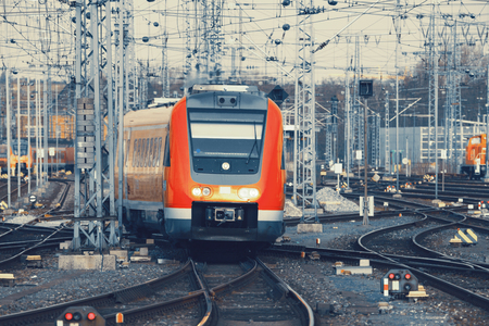 Modern orange commuter train on a railroad. Railway station in Europe. Railroad with vintage toning.のeditorial素材