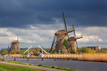 Windmills against cloudy sky at sunset in famous Kinderdijk, Netherlands. Rustic landscape with...