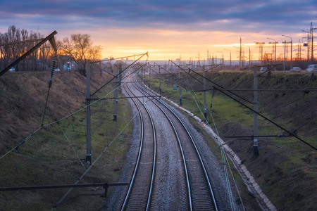Beautiful view from the bridge on the railroad at sunset. Colorful industrial landscape with railway...