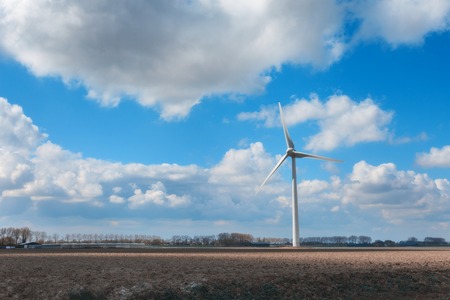 Wind turbines generating electricity. Windmills for electric power production. Landscape with wind mills generating energy on the field and colorful blue sky with clouds at sunset in spring in Germanyの写真素材