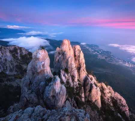 Mountain landscape at sunset. Amazing view from mountain peak on the high rocks, blue sky, red clouds and sea in the evening. Low clouds. Colorful nature background. Adventure. Travel in Crimeaの写真素材