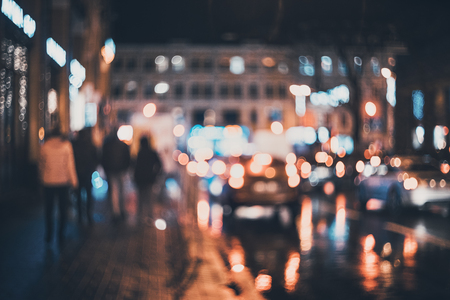 Blurred city at night. Bokeh. Beautiful abstract background with defocused buildings, cars, city lights, people. Colorful bokeh background with urban night scene. Design. Concept backdrop. Vintageの写真素材