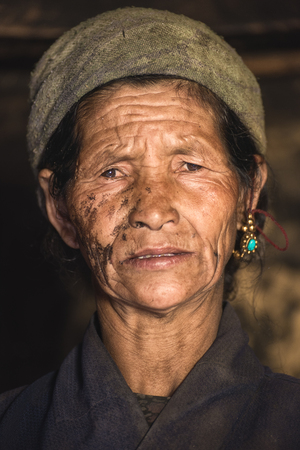 Prok village / Nepal - October 14 2017. Portrait of a old nepalese woman in national clothes in her house. Travel in Asia. Close up. Asian senior woman indoor. Tribe in Himalayas. Old aged femaleのeditorial素材