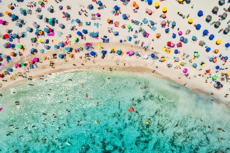 Aerial view of sandy beach with colorful umbrellas, swimming people in sea bay with transparent blue water in sunny morning in summer. Travel in Mallorca, Balearic islands, Spain. Top view. Landscapeの写真素材