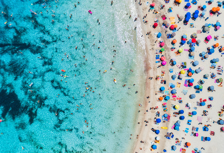 Aerial view of sandy beach with colorful umbrellas, swimming people in sea bay with transparent blue water in sunny day in summer. Travel in Mallorca, Balearic islands, Spain. Top view. Landscapeのeditorial素材
