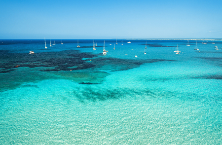 Aerial view of boats and luxury yachts in transparent sea at sunny bright day. Summer seascape. Tropical landscape with lagoon, boats, azure water, sandy beach, blue sky. Top view from drone. Travelの写真素材