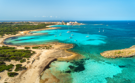 Aerial view of beautiful sea with transparent azure water, rocks, sandy beach, green trees, boats and luxury yachts at sunny day in summer. Mallorca, Spain. Colorful seascape. Top view from droneの写真素材