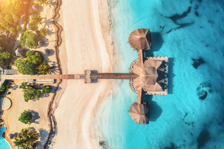 Aerial view of beautiful hotel in Indian ocean at sunrise in summer. Zanzibar, Africa. Top view.  Building on the sea. Aerial landscape with wooden hotel, clear azure water, sandy beach. Luxury resortのeditorial素材