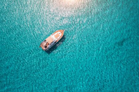 Aerial view of luxury yacht in transparent blue sea at sunny day in summer in Mallorca, Spain. Colorful landscape with boat, bay, clear azure water. Top view from air. Travel. Seascape with motorboatの写真素材