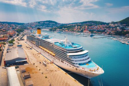 Aerial view of cruise ship in harbor. Top view of beautiful large ships and boats at sunny day. Landscape with harbour, city, buildings, mountains, blue sea. Luxury cruise. Floating liner in portの写真素材