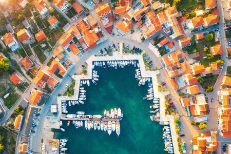 Aerial view of boats and yachts in port in old city at sunset. Summer landscape with houses with...