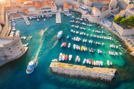 Aerial view of boats and yachts in port in old city in Dubrovnik at sunset. Summer landscape with buildings, motorboats in harbor, transparent blue sea. Beautiful architecture. View from above. Travelの写真素材