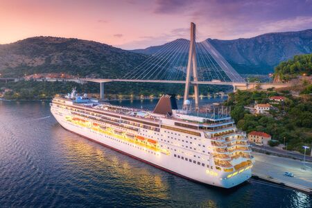 Aerial view of cruise ship and beautiful bridge at night. Port in Dubrovnik, Croatia. Summer...