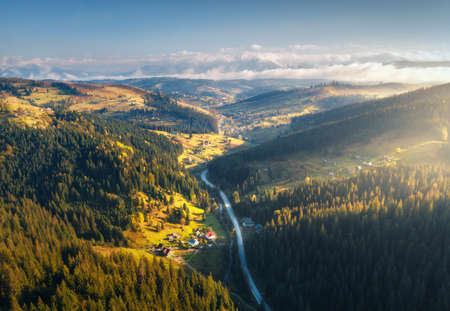 Aerial view of beautiful road in mountains at sunrise in autumnの写真素材
