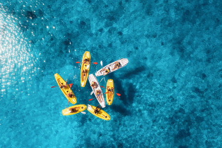 Aerial view of yellow kayaks in blue sea at sunset in summerの写真素材