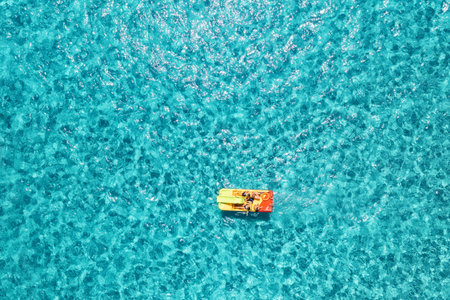 Relaxing people on the colorful boat in blue sea at sunny dayの写真素材