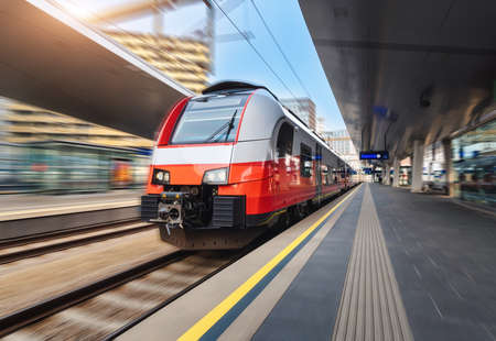 High speed train in motion on the railway station at sunsetの写真素材