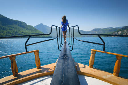 Young woman on the floating yacht on the sea at sunny bright dayの写真素材