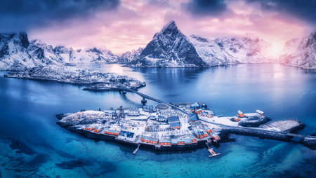 Aerial view of snowy islands with houses, rorbu, blue seaの写真素材