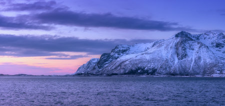 Beautiful snow covered mountains and purple sky in waterの写真素材
