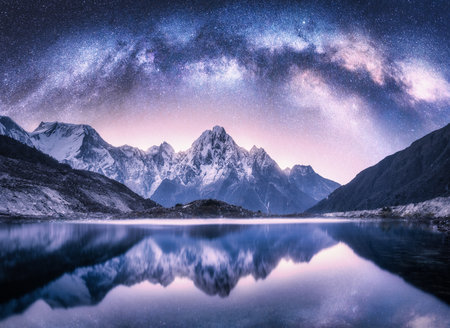 Milky Way arch over snowy mountains and lake at nightの写真素材