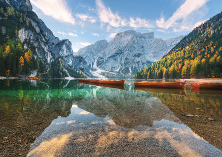 Beautiful wooden boats on Braies lake at sunrise in autumnの写真素材