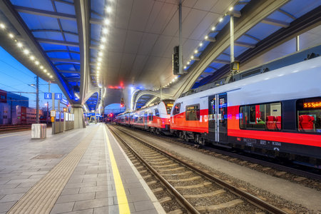 High speed train on the modern railway station at nightの写真素材