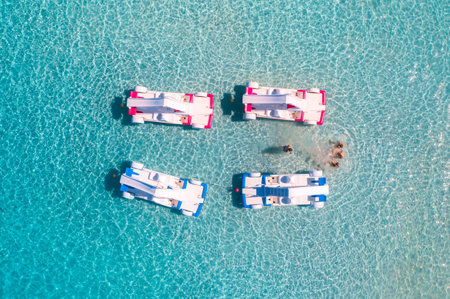 Aerial view of catamarans, swimming people in blue sea in summerの写真素材