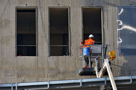 Besançon, France - November 25, 2014: Construction workman on a cherry picker preparing the installation of windows on a construction site.のeditorial素材
