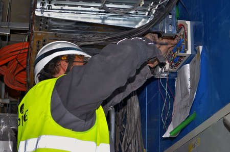 Besançon, France - December 22, 2014: Electrician working on an electrical device on a construction site.のeditorial素材