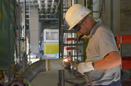 Besançon, France - September 26, 2014: Workman weldind a piping on a construction site.のeditorial素材