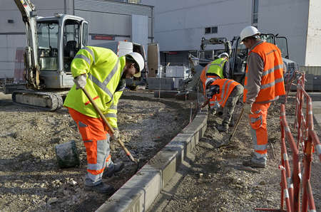 Besançon, France - November 25, 2014: Workmen constructing the edge of a sidewalk on a construction site.のeditorial素材