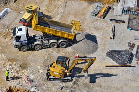Besançon, France - June 20, 2013: High angle view of a steamroller, a dump trunck and an excavator on a construction site.のeditorial素材
