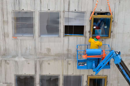 Besançon, France - November 3, 2014: Construction workman on a cherry picker preparing the installation of windows on aのeditorial素材