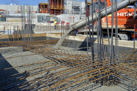 Besançon, France - July 23, 2013: Workmen pouring wet concrete on a construction site.のeditorial素材