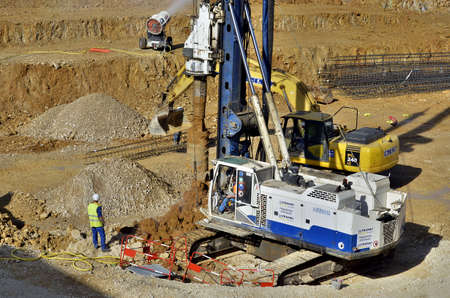 Besançon, France - April 17, 2013: Workmen, drilling machine and excavator on a construction site.のeditorial素材